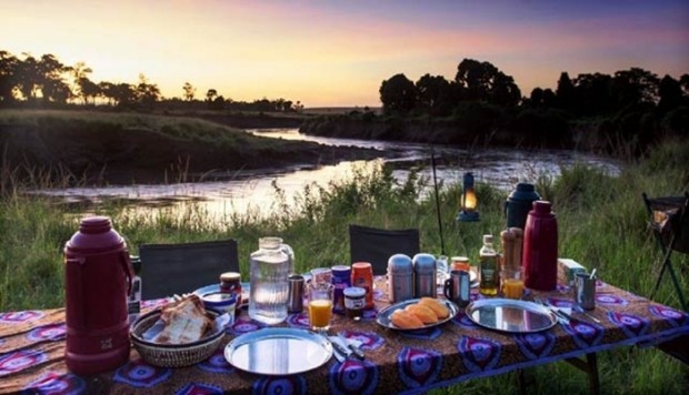 Comida y mesa junto a un río durante un viaje en camión por África